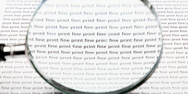 A page of text repeating the words 'FINE PRINT' in black text with a magnifying glass looking over it. A page of text repeating the words 'FINE PRINT' in black text with a magnifying glass looking over it.