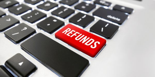 A white keyboard with black keys, one key is red coloured with white text, it reads 'REFUNDS' A white keyboard with black keys, one key is red coloured with white text, it reads 'REFUNDS'