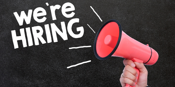 A person holding a red megaphone with white text coming from it that reads 'WE'RE HIRING' A person holding a red megaphone with white text coming from it that reads 'WE'RE HIRING'