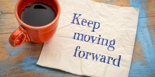 a napkin with the words 'KEEP MOVING FORWARD' next to a coffee cup. a napkin with the words 'KEEP MOVING FORWARD' next to a coffee cup.