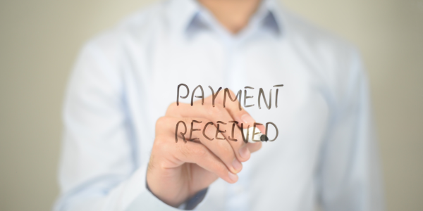 Person writing on a sheet of glass the words 'PAYMENT RECEIVED' can be seen in black ink Person writing on a sheet of glass the words 'PAYMENT RECEIVED' can be seen in black ink