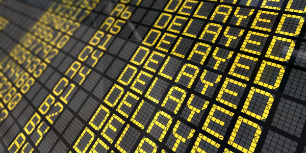 a black board with yellow wording that reads 'DELAYED' a black board with yellow wording that reads 'DELAYED'