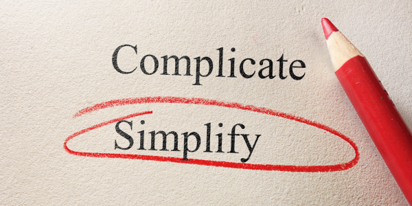 two words typed on a piece of paper 'COMPLICATE' and 'SIMPLIFY' the word 'SIMPLIFY' is circled in red pencil. two words typed on a piece of paper 'COMPLICATE' and 'SIMPLIFY' the word 'SIMPLIFY' is circled in red pencil.