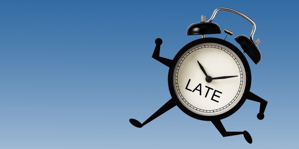 A clock with arms and legs running, on the clock face the word 'LATE' can be seen. A clock with arms and legs running, on the clock face the word 'LATE' can be seen.