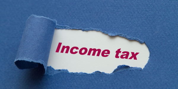 A blue sheet of paper with a tear in the middle, through the tear the words 'INCOME TAX' can be seen in red text. A blue sheet of paper with a tear in the middle, through the tear the words 'INCOME TAX' can be seen in red text.