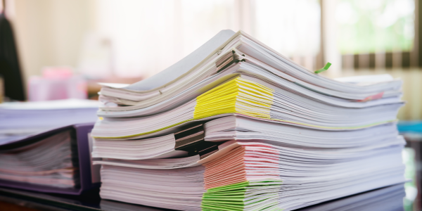 A large amount of files sat on a desk. A large amount of files sat on a desk.