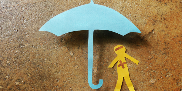 Paper cutouts of a worker stood underneath an umbrella. Paper cutouts of a worker stood underneath an umbrella.