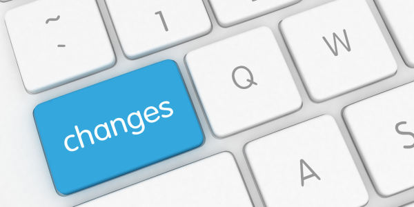 A white keyboard with a blue key, this key reads the word 'CHANGES' in white text. A white keyboard with a blue key, this key reads the word 'CHANGES' in white text.