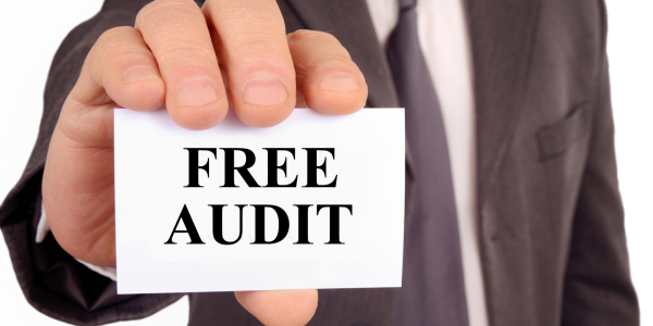 A person holding out a white card with the words 'FREE AUDIT' typed on it A person holding out a white card with the words 'FREE AUDIT' typed on it