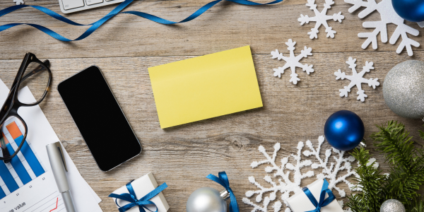 A desk with a pair of glasses, a mobile phone and various Christmas decorations. A desk with a pair of glasses, a mobile phone and various Christmas decorations.