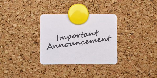 A brown pin board with a white card fixed onto it, the card reads 'IMPORTANT ANNOUNCEMENT' A brown pin board with a white card fixed onto it, the card reads 'IMPORTANT ANNOUNCEMENT'