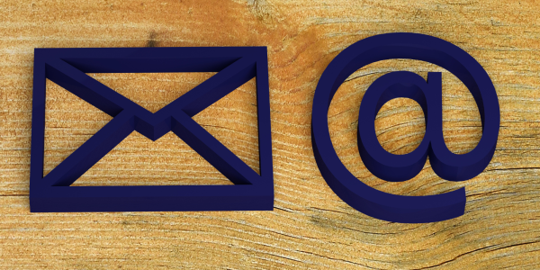 A wooden background with 2 symbols the mail (letter) symbol and the email symbol (@) A wooden background with 2 symbols the mail (letter) symbol and the email symbol (@)