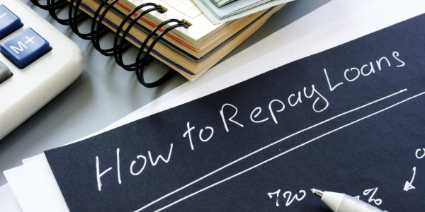 black paper with white writing saying 'HOW TO REPAY LOANS'