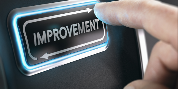 A person pressing a button that has the word 'IMPROVEMENT' on it A person pressing a button that has the word 'IMPROVEMENT' on it