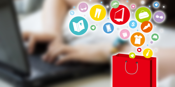 Icons of things you pay purchase online floating into a shopping bag, in the background a person can be seen typing on a laptop Icons of things you pay purchase online floating into a shopping bag, in the background a person can be seen typing on a laptop