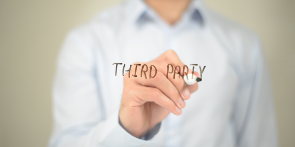 A person writing the words 'THIRD PARTY' on a clear screen with a black pen