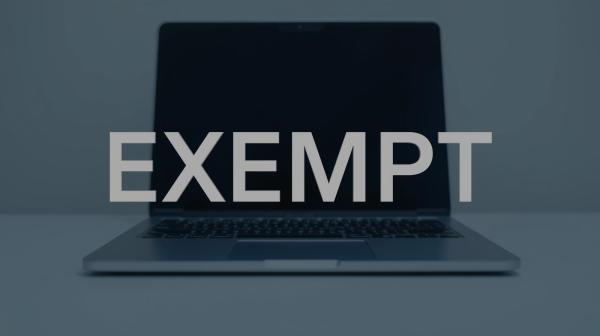 the word 'EXEMPT' in front of an open laptop 