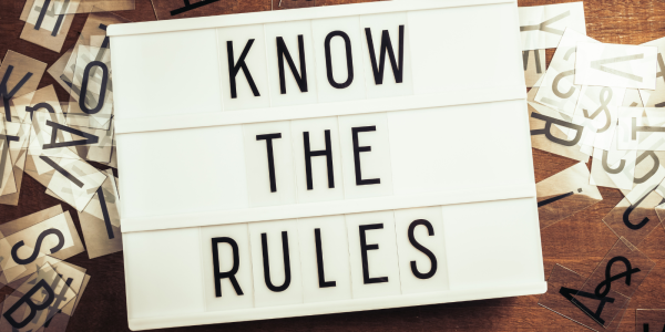 A light board with letter tiles on that make up the words 'KNOW THE RULES'