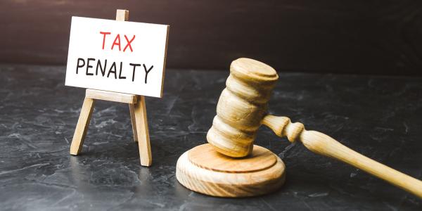 A hammer, gavel and a tiny canvas on a stand that reads 'TAX PENALTY' 