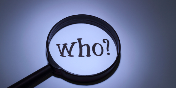 A magnifying glass hovering over the word 'WHO?'