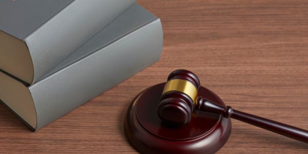  A hammer, gavel and a 2 books on a wooden desk