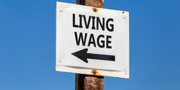 A sign post with the words 'LIVING WAGE' and an arrow 
