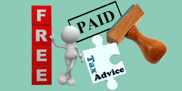 A man stood up against a wall of lettered tiles spelling out the word 'FREE', a stamper that has printed the word 'PAID' and a jigsaw piece with the words 'TAX ADVICE' printed on it.