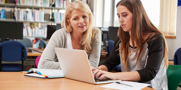 one person watching as the other uses the laptop