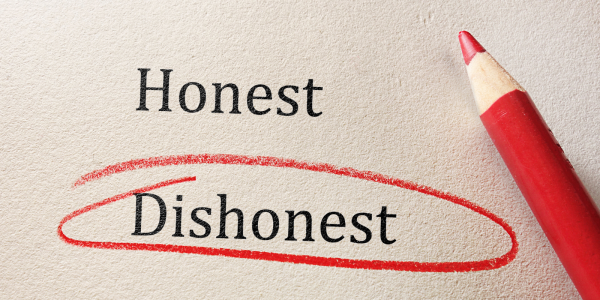 A piece of paper with 2 words typed on it 'HONEST' and 'DISHONEST' the word dishonest has been circled with red pencil.