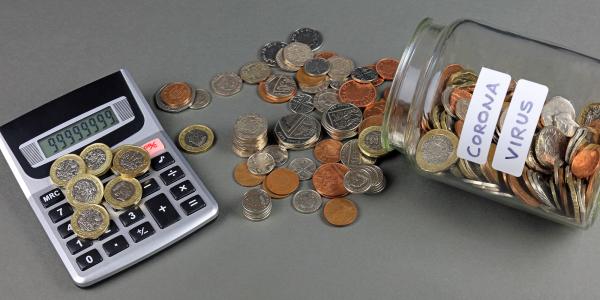 Image of a jar of coins with the word coronavirus on it next to a calculator