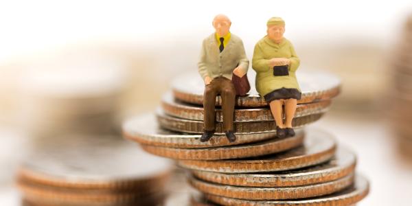 Image of models of pensioners sitting on a pile of coins