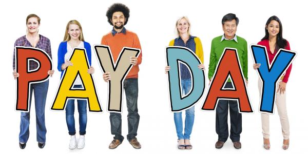 People holding letters spelling pay day