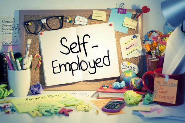 self employed writing in a book in a colourful office