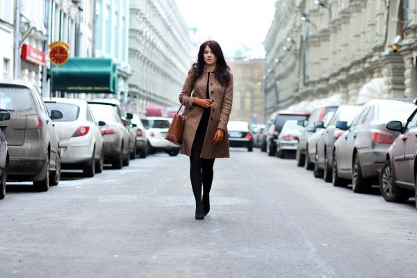 Woman walking in the middle of a road.